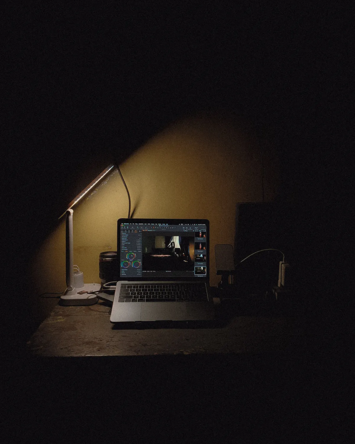 Ruhiger, dunkler Arbeitsplatz mit Laptop und Schreibtischlampe